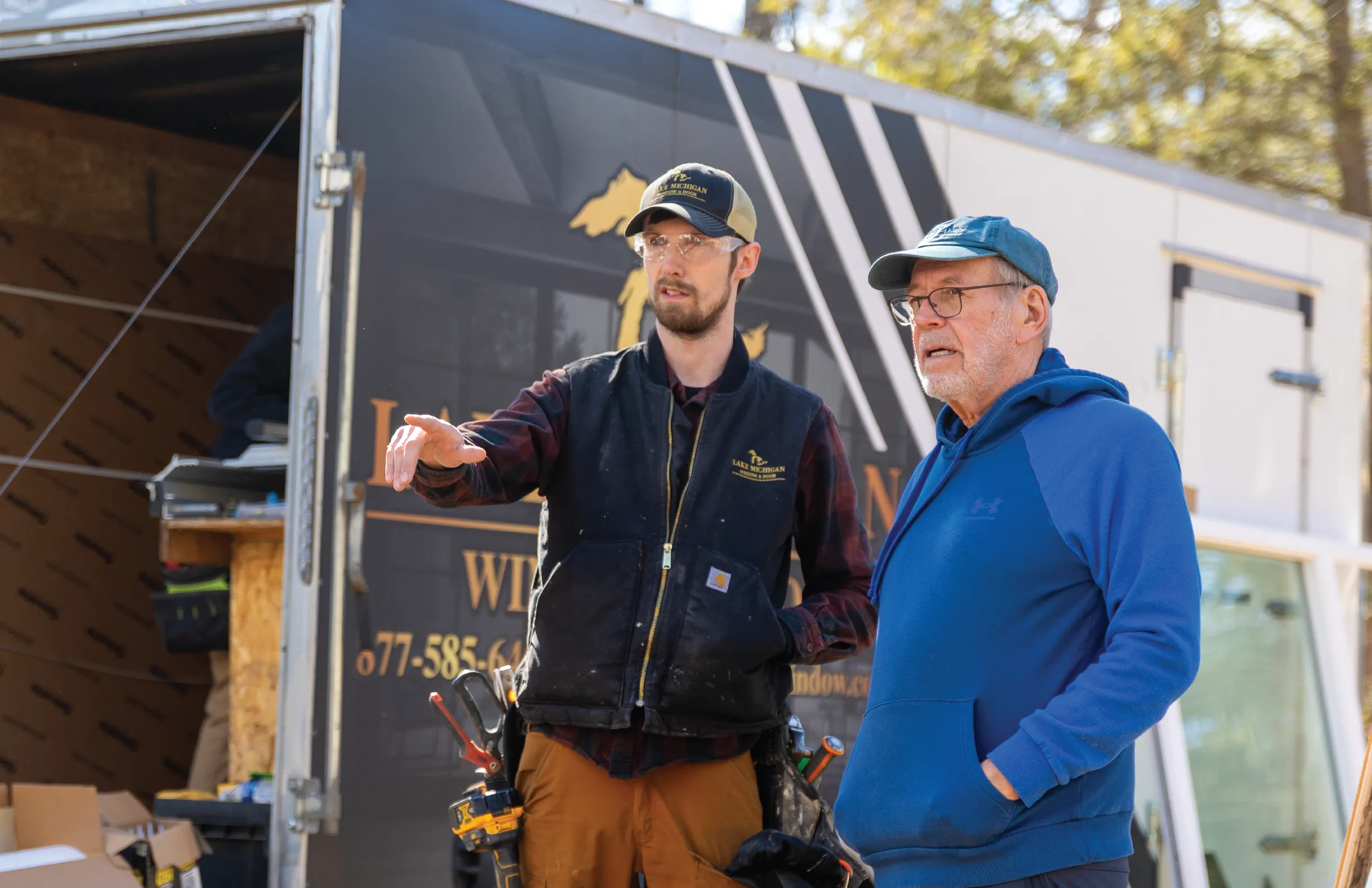 team member and man in front of vehicle