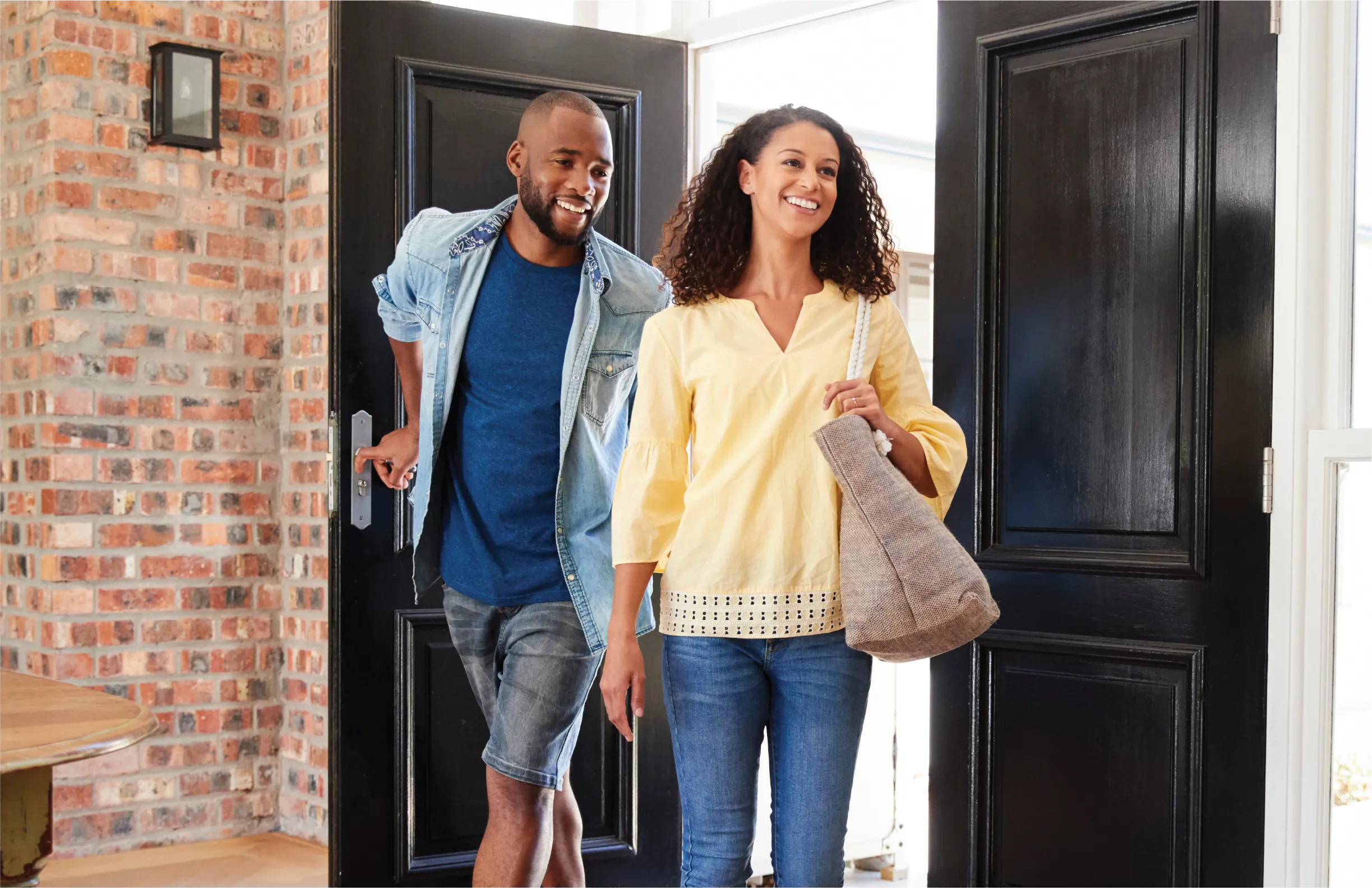 Photo of a husband and wife walking through a door.